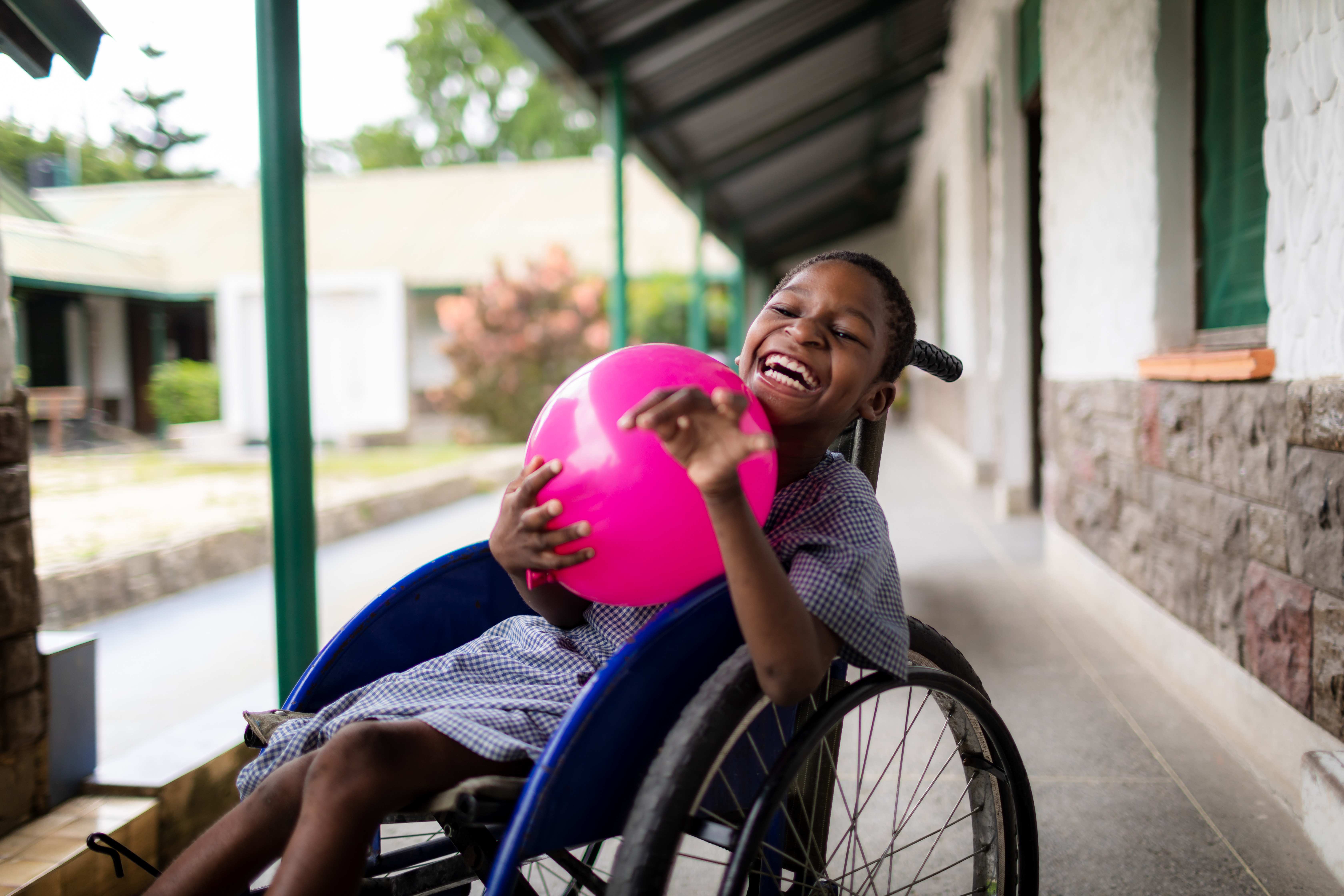 A child in a wheel chair plays with a balloon (source: Lars Heidrich)