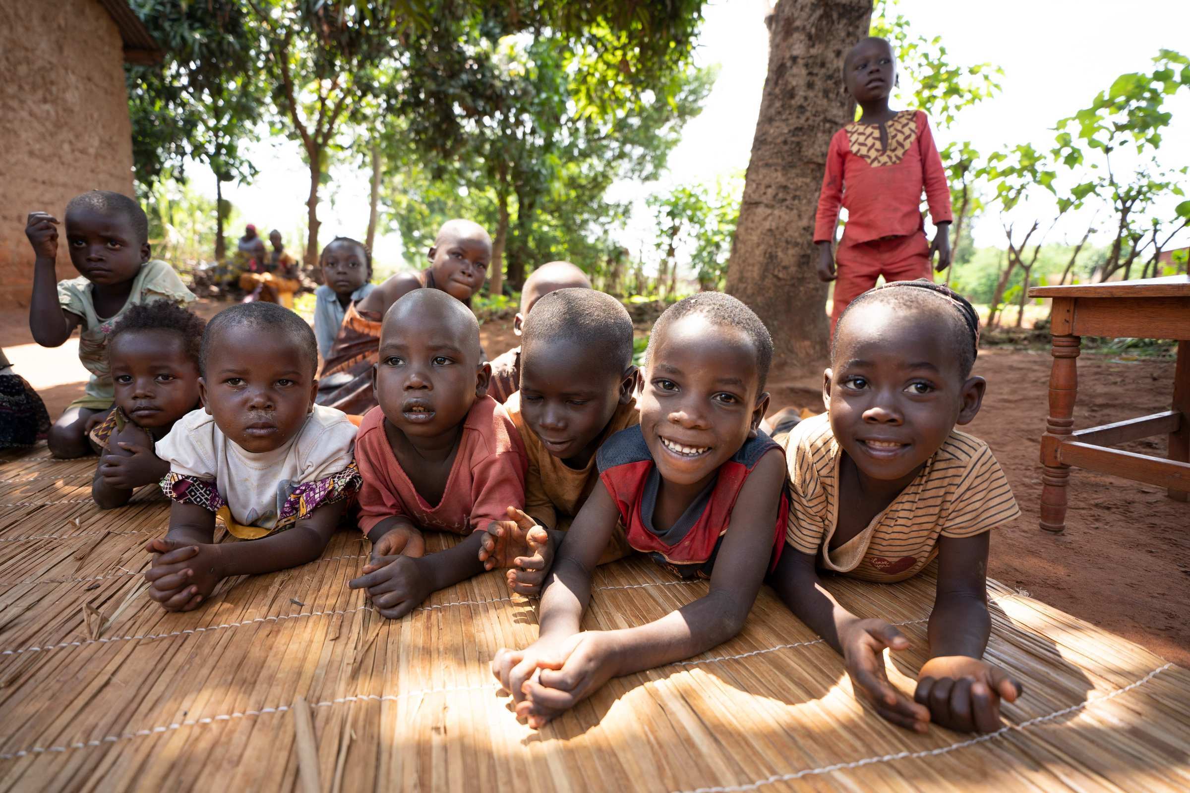 Children from Burundi lie on a mat (Source: Christian Nusch)