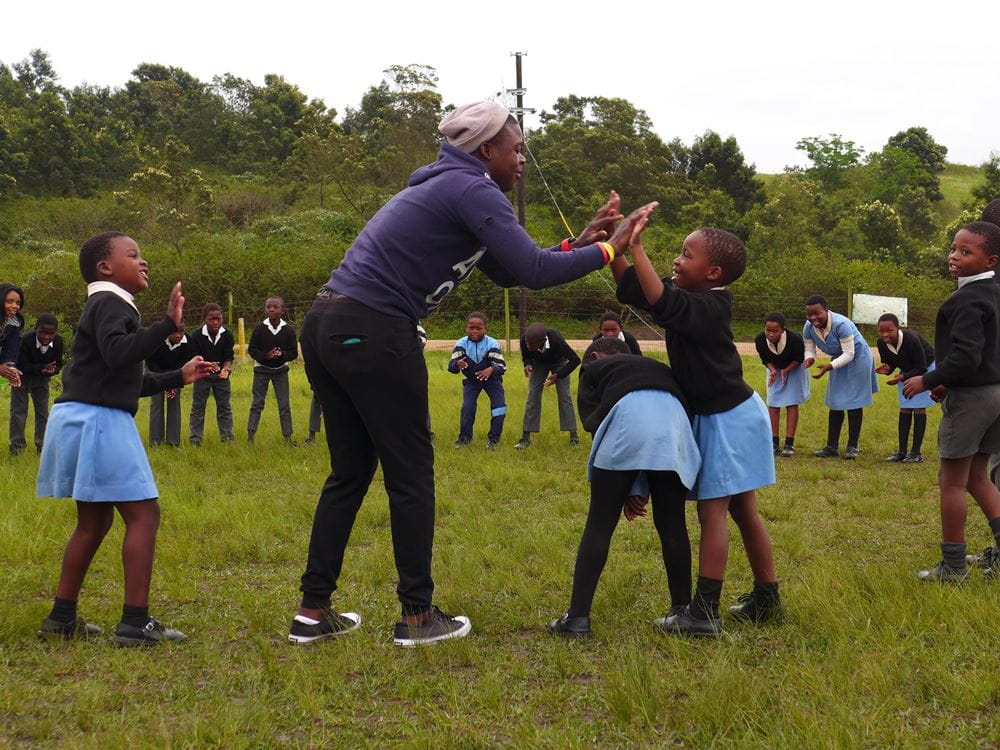 Children play in a circle outside a clapping game with a care giver (source: Niklas Alof) Children play in a circle outside a clapping game with a care giver (source: Niklas Alof)