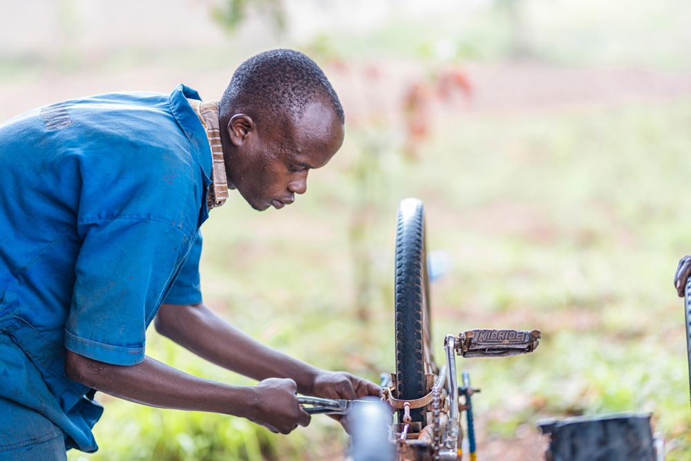 Ein Jugendlicher repariert ein Fahrrad, Community-Based Training (Quelle: Martin Bondzio) A teenager repairs a bike, Community-Based Training (Quelle: Martin Bondzio)