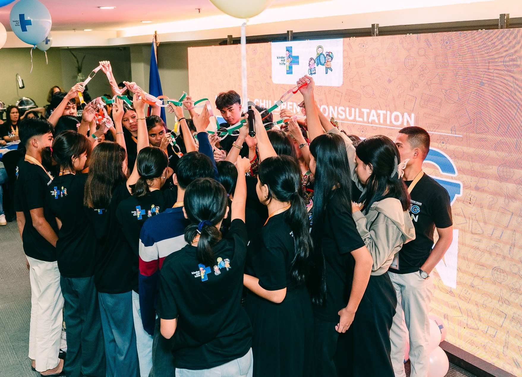 Children hold a paper chain in the air on the National Children Consultation (Source: Kindernothilfe-Partner)